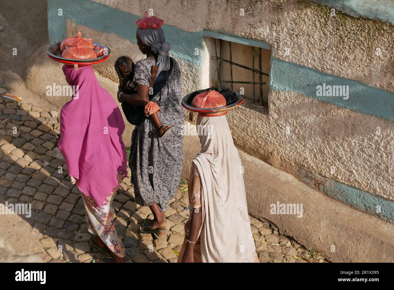 Harar, Ethiopia â€“ 11.03.2022: harari women walk to market carrying their wares on their head Stock Photo