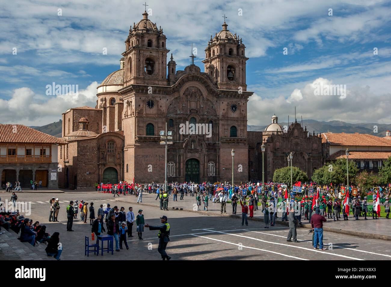 A parade takes place in front of The Church of the Society of Jesus at Plaza de Armas at Cusco in Peru. Stock Photo