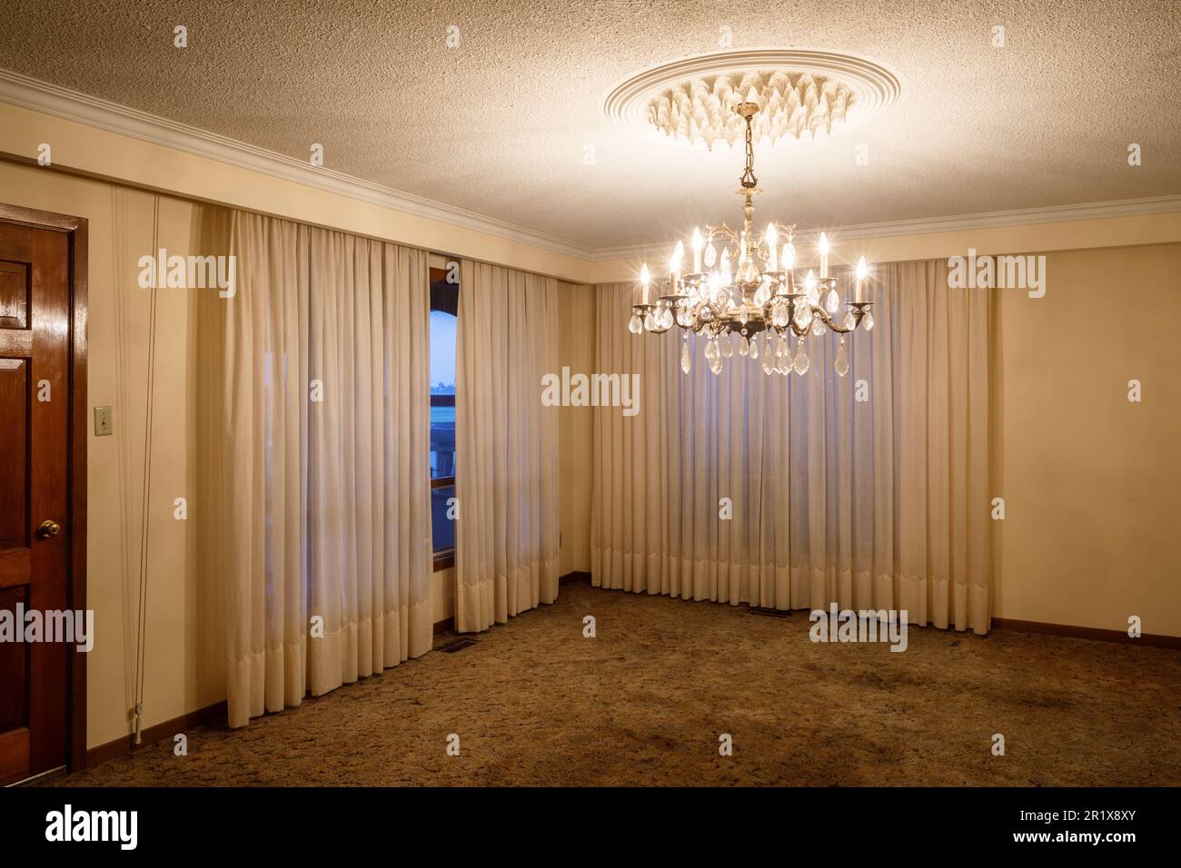 A chandelier and ceiling medallion hanging in a living room.   This house has since been demolished. Stock Photo