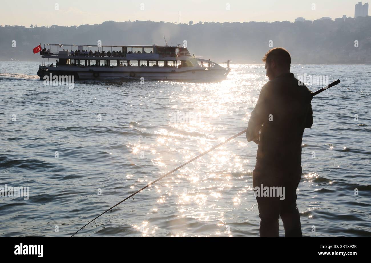 Amateur fisherman is fishing on Cengelköy Coastline at sunset in Istanbul, Turkey. Stock Photo