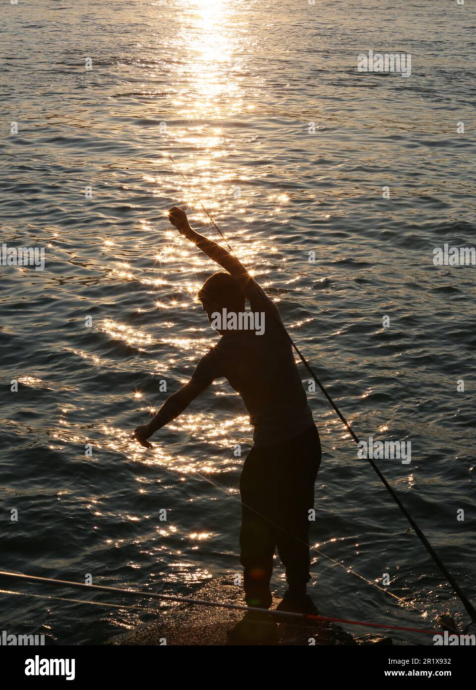 Amateur fisherman is fishing on Cengelköy Coastline at sunset in Istanbul, Turkey. Stock Photo