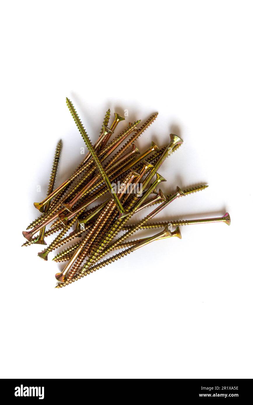 Long gold screws in a pile, shot from above, isolated on white