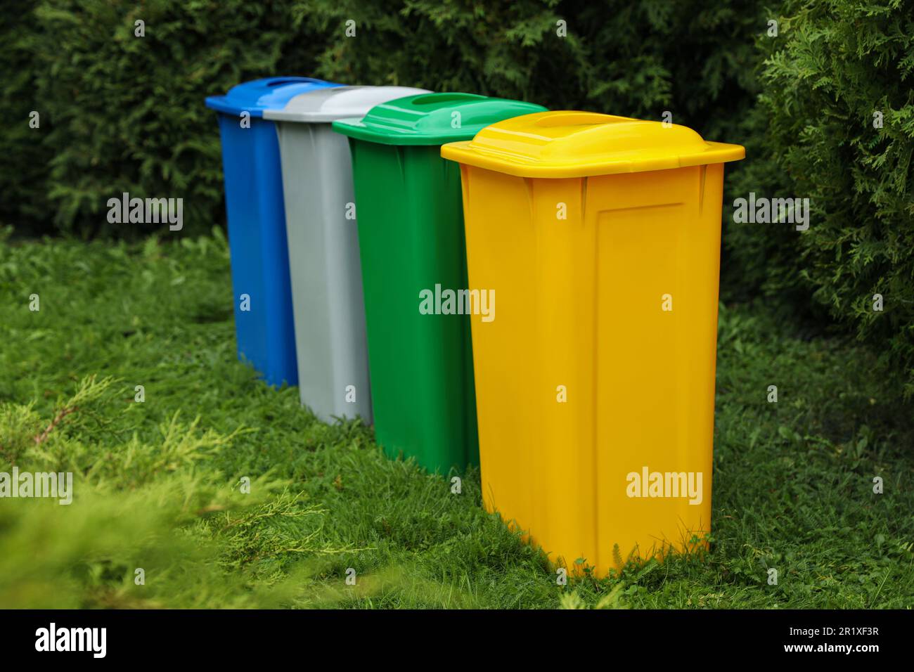 Many color recycling bins on green grass outdoors Stock Photo - Alamy