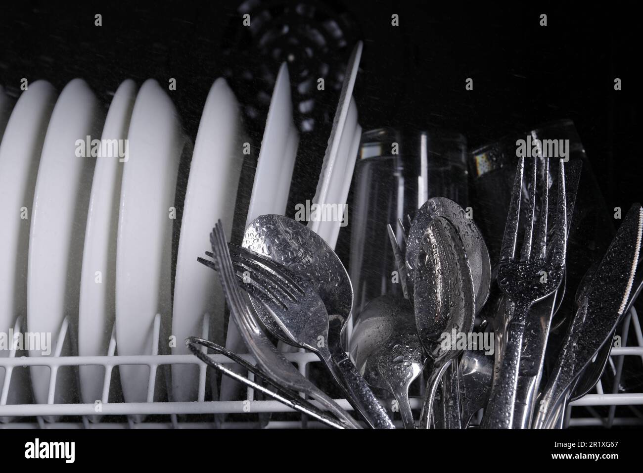 Clean wet plates and cutlery in dishwasher, closeup Stock Photo Alamy