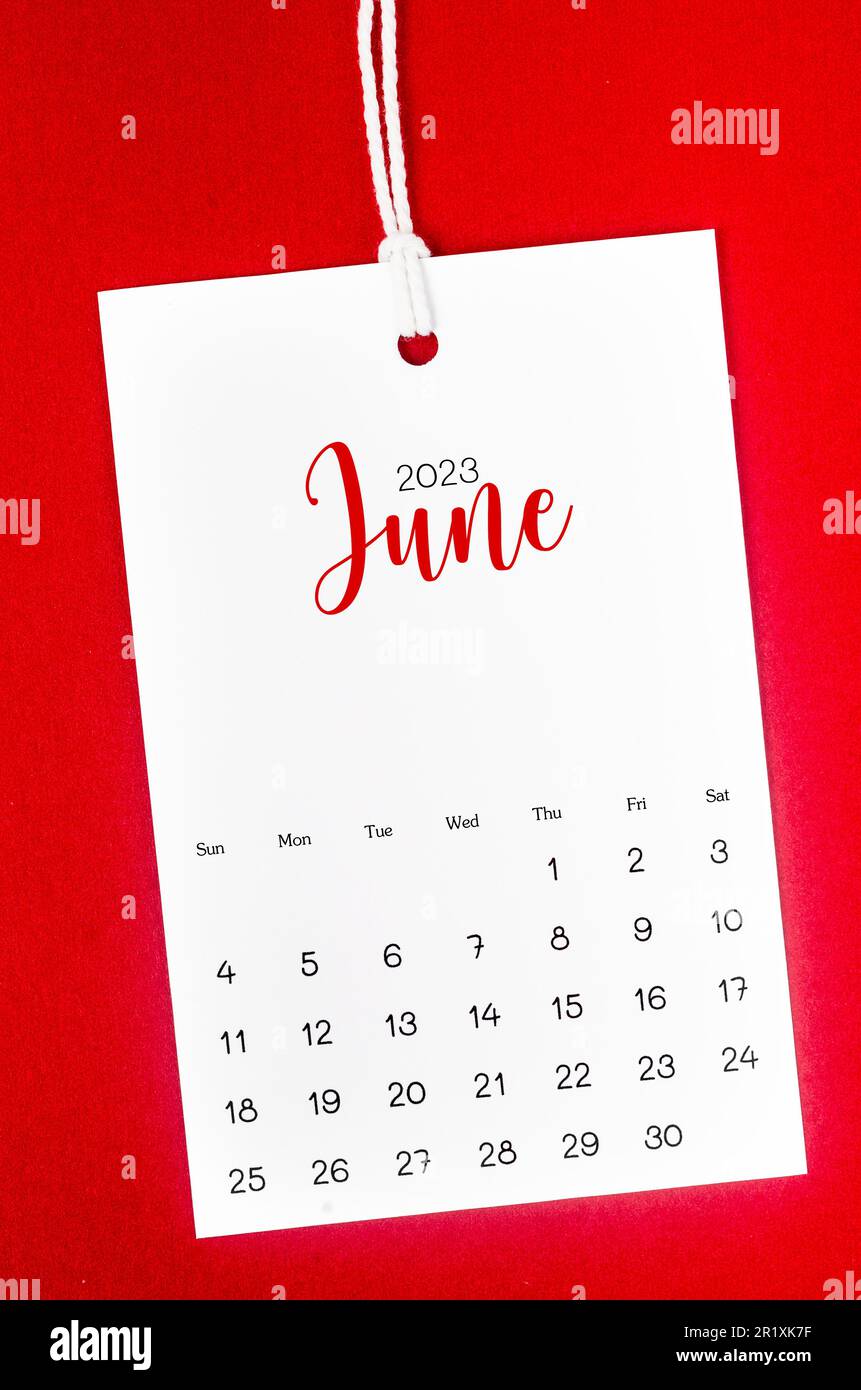 June 2023 calendar page for 2023 year hanged on white rope on red