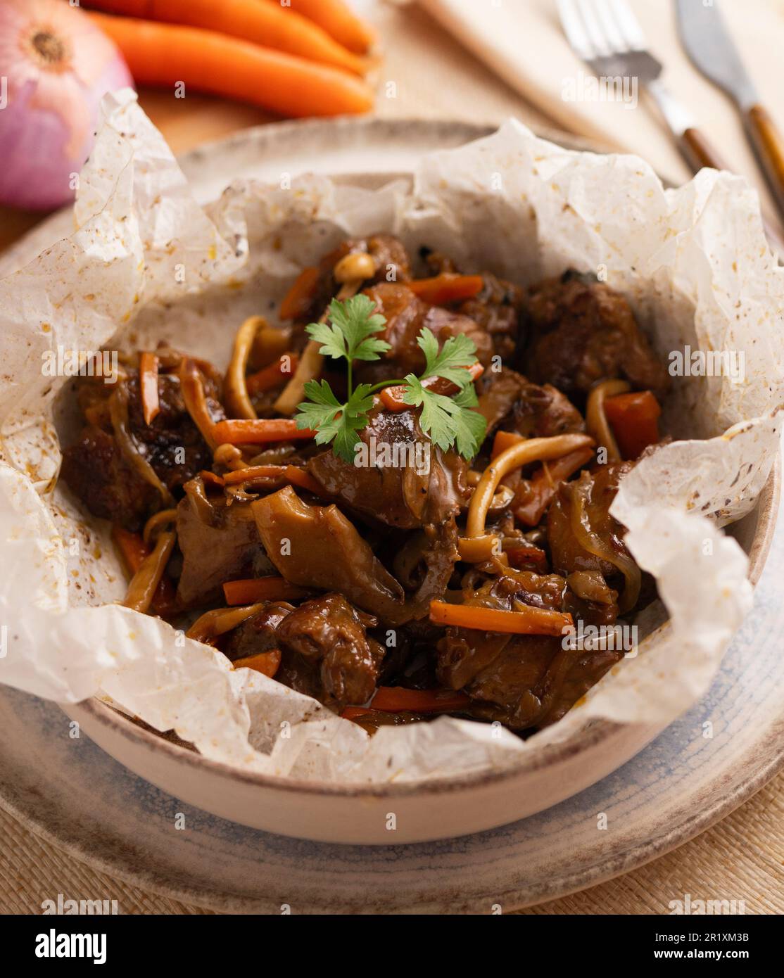 Lamb cooked in papillote with vegetables. Stock Photo