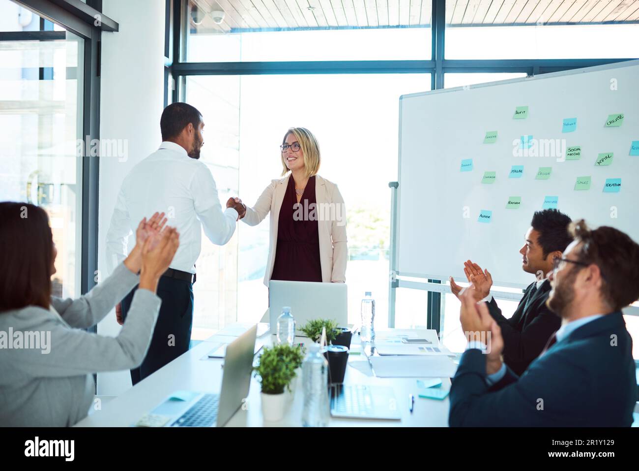 Professional, handshake and agreement in a meeting to congratulate for success and an opportunity. Presentation, applause and business people with Stock Photo