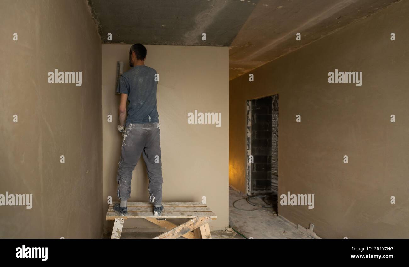 Photo inspiration: Fresh Look at Construction Worker Wearing Worker Overall With Wall Plastering Tools
