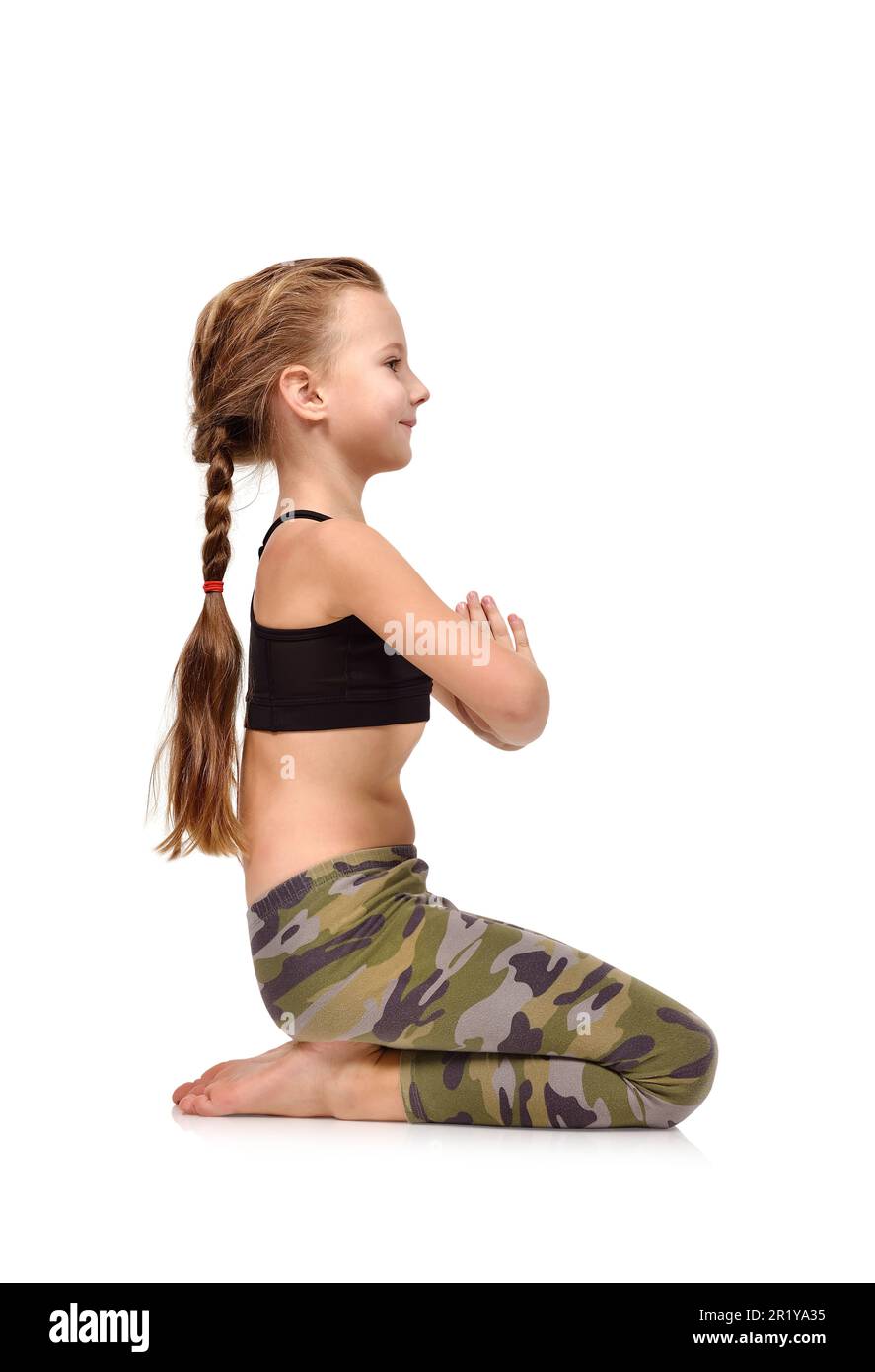 Little girl in camo clothing sitting lotus position on white background Stock Photo