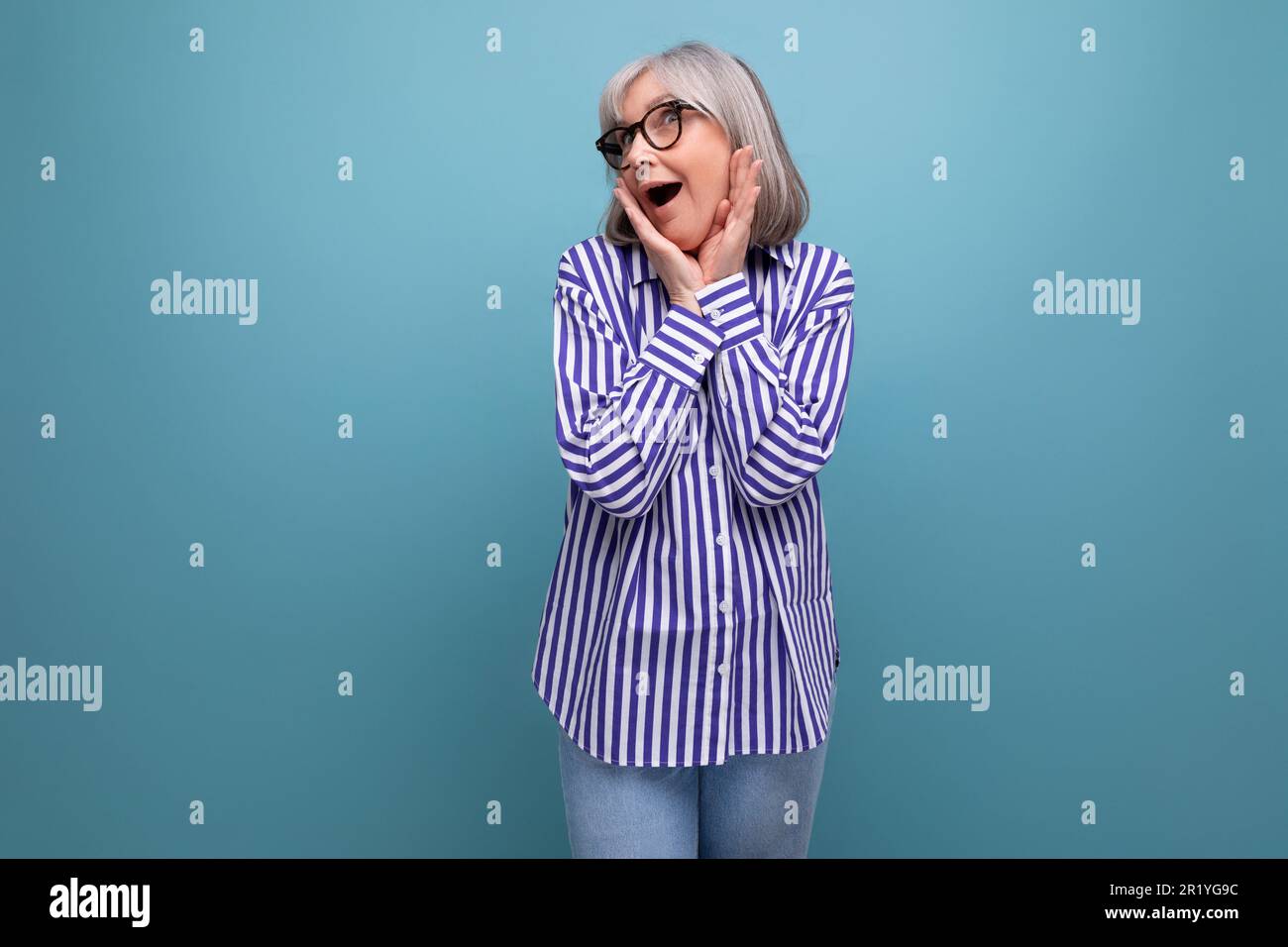 surprised middle-aged youth lady with gray hair on a bright studio background with copy space Stock Photo