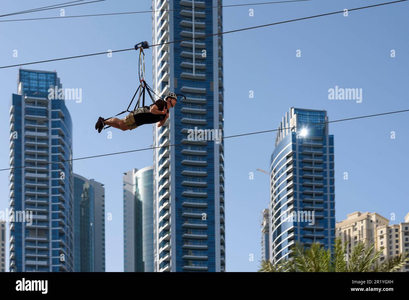 A tourist zip wires past the skyscrapers in Dubai Marina, Dubai, United