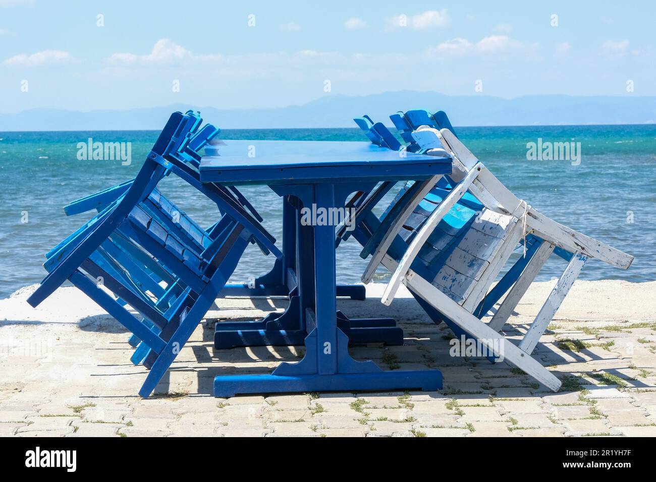 Empty blue white wooden chairs and table near sea. Sea sky travel table chair background. Stock Photo