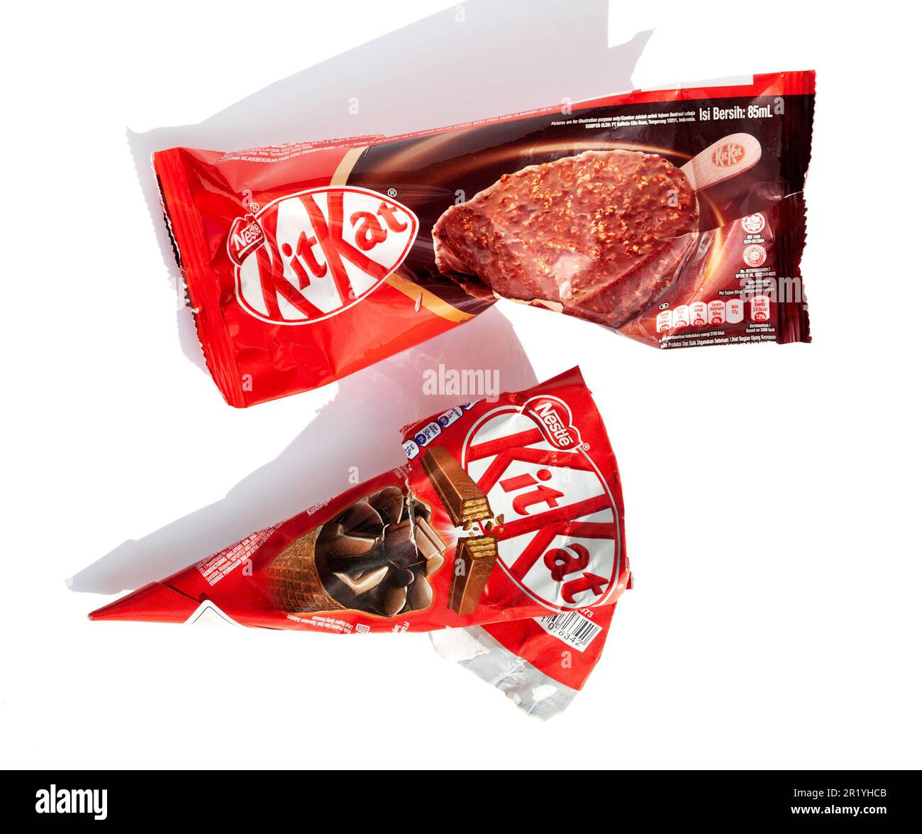 Ho Chi Minh City, Vietnam - May 10, 2023: 2 different types of KitKat ice cream torn wrappers isolated on white. Popular dessert Kit Kat red packaging Stock Photo