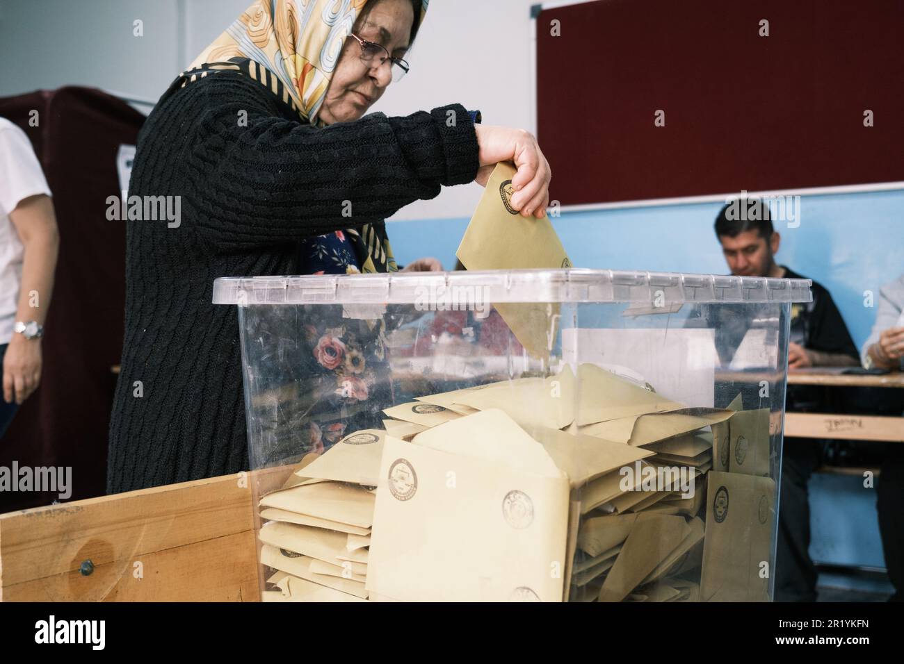 Izmir, Turkey - May 14, 2023: An elderly woman, around 60-70 years old, is captured in the moment of casting her vote in the Presidential and Parliame Stock Photo
