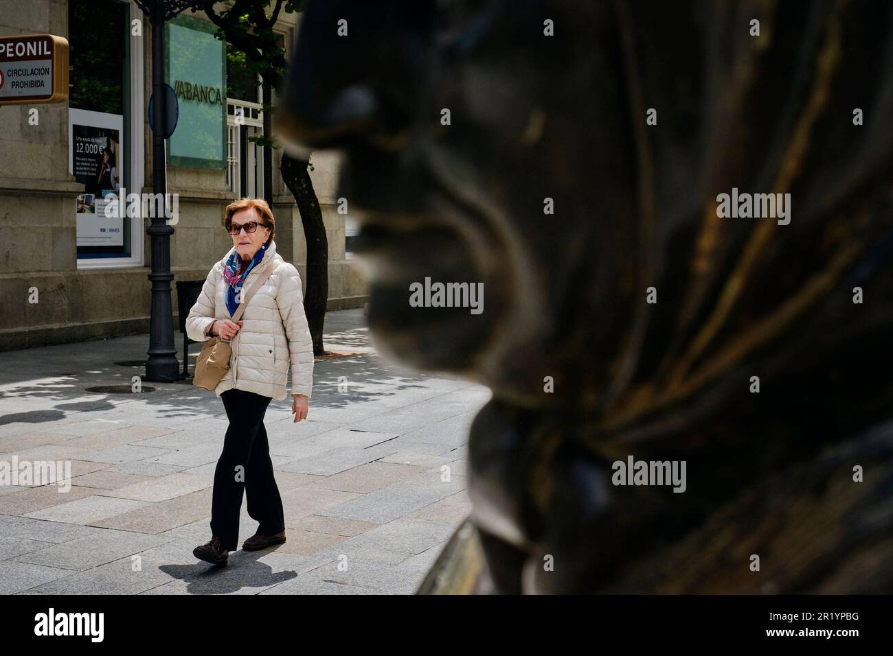 A lady walks along one of the city streets on May 15, 2023, in Ourense,  Galicia (Spain). The Council of Ministers has agreed on the design of a  program aimed at encouraging