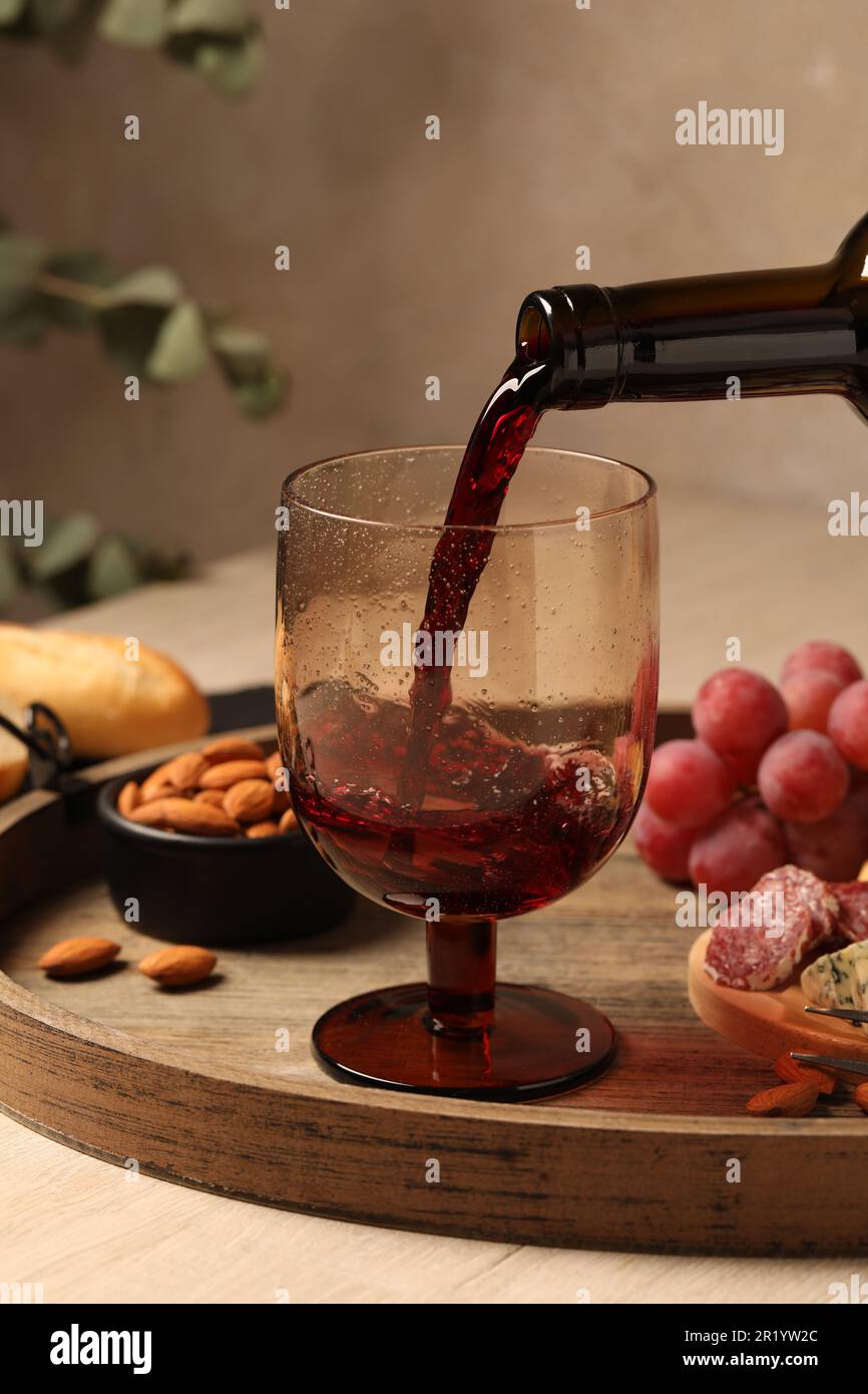 https://c8.alamy.com/comp/2R1YW2C/pouring-red-wine-into-glass-at-wooden-table-closeup-2R1YW2C.jpg
