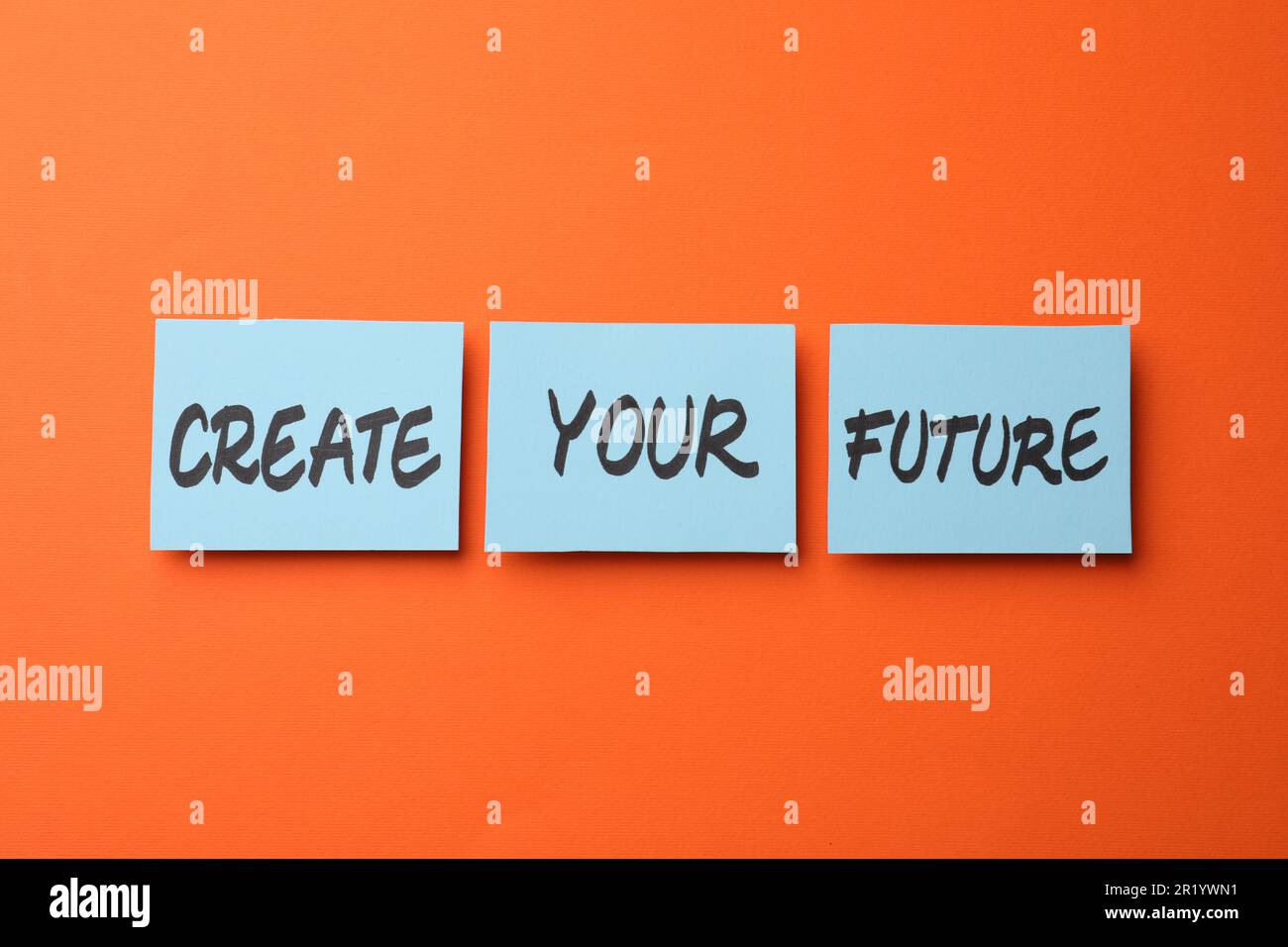 Motivational phrase Create Your Future made of sticky notes with words on orange background Stock Photo
