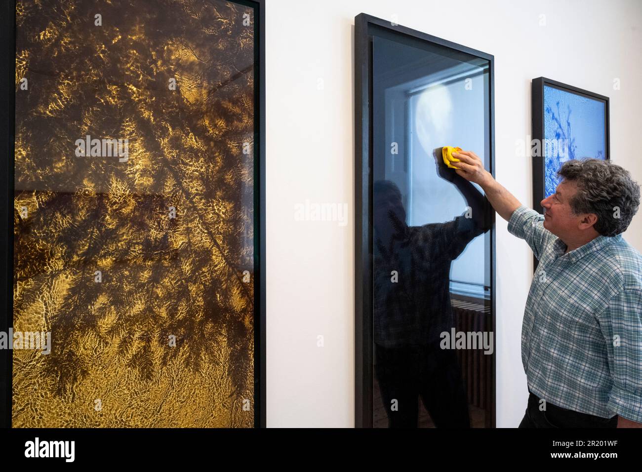 London, UK.  16 May 2023.  Photographer Alexander Lindsay with 'River Taw The Streens, Gold Fir', 1998-2020, and 'Half Moon Fir', 2003, both by Susan Derges, at the first ‘Space to Breathe’ exhibition.  Works by four British artists are on show at Cromwell Place in South Kensington ahead of the main exhibition and festival, at Bowhouse, in the East Neuk of Fife, Scotland 15 July to 6 August 2023.    Credit: Stephen Chung / Alamy Live News Stock Photo