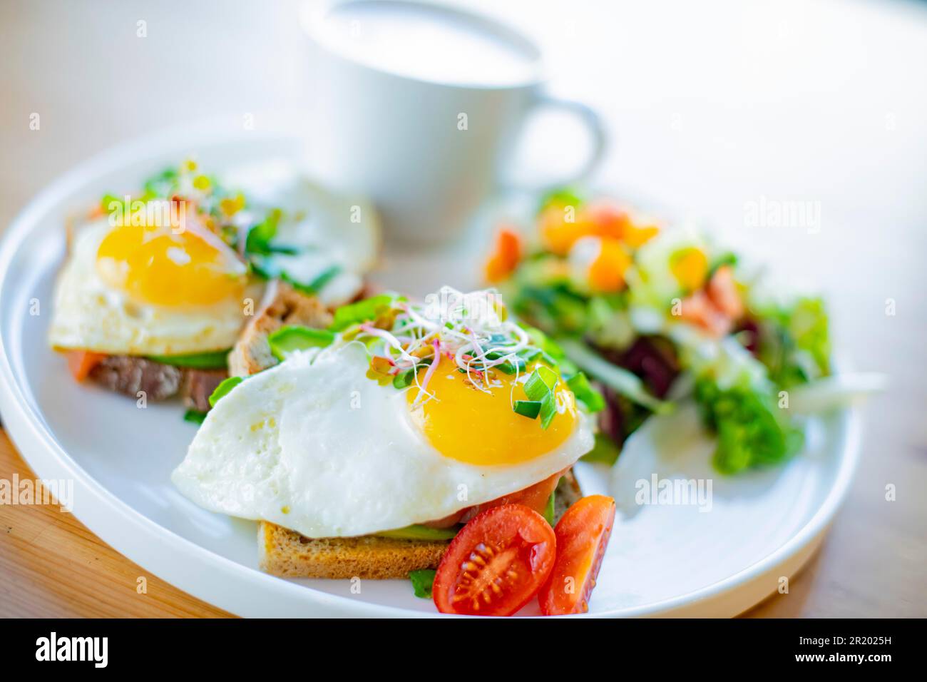Breakfast with fried eggs on toasts on a restaurant table Stock Photo