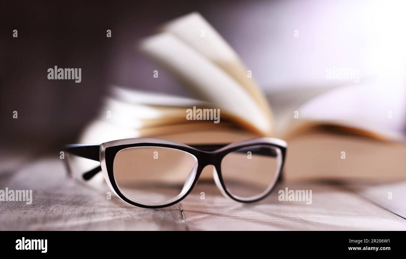 Composition with glasses and open book on the table Stock Photo