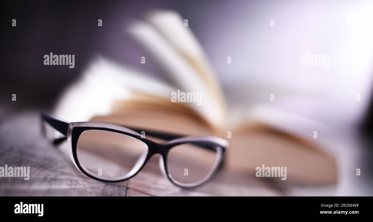 Composition with glasses and open book on the table Stock Photo