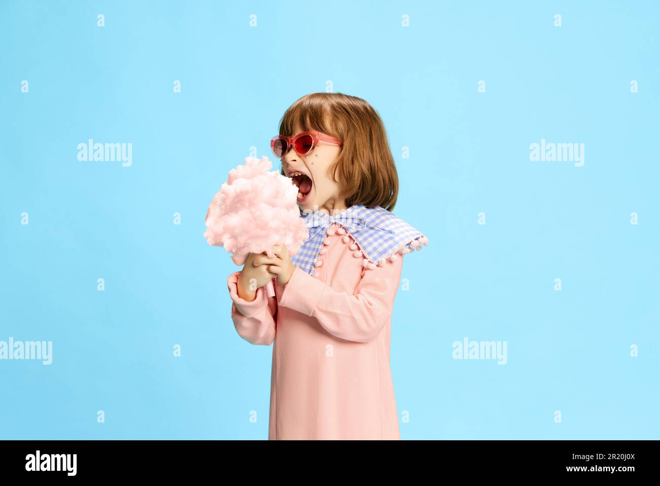 Portrait of happy, delightful little girl in tender pink dress and ...