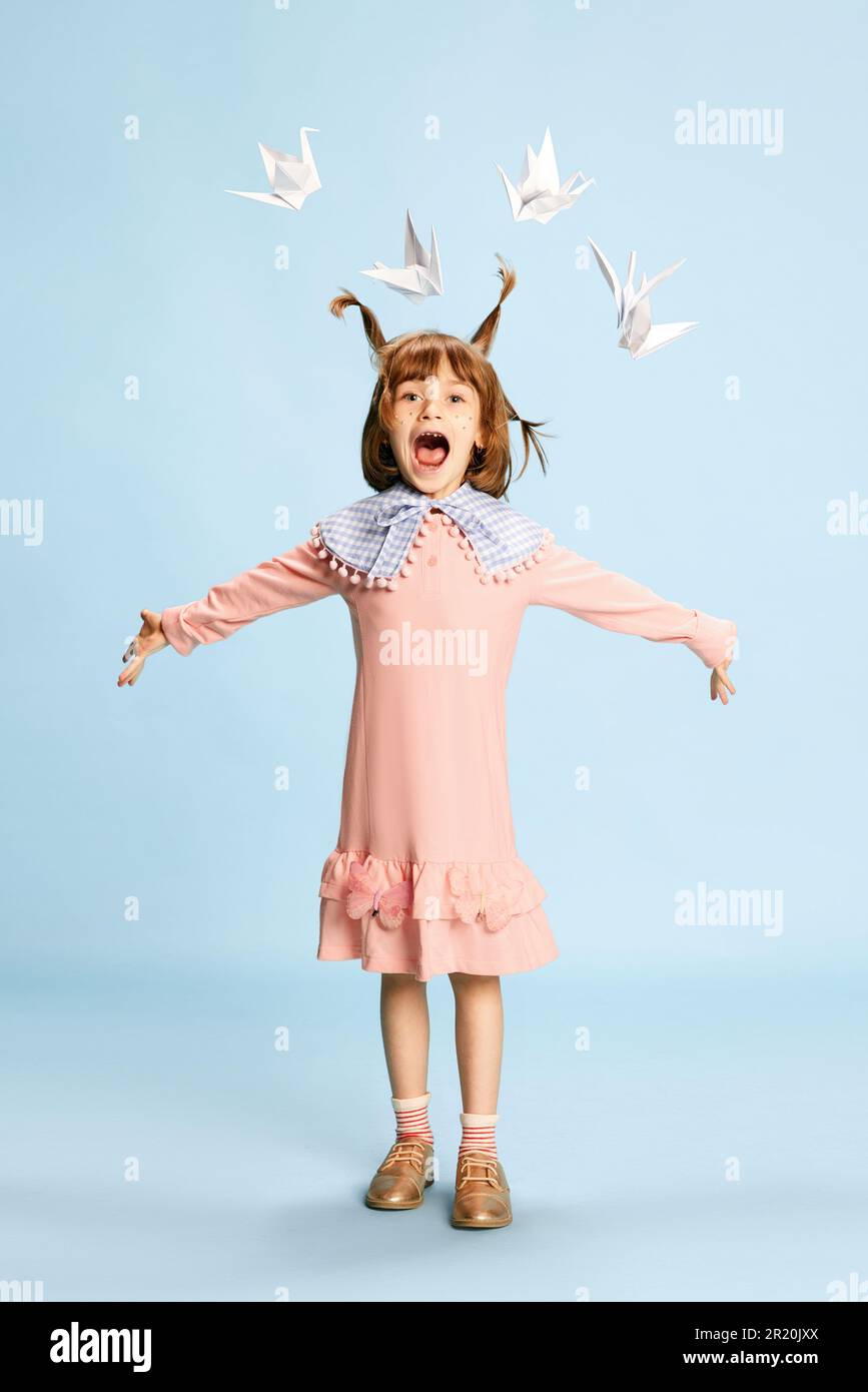 Full-length portrait of happy little girl, child in pink dress posing ...
