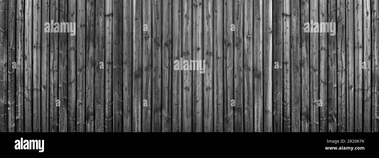 Dark grey wooden wall made of vertical planks with intense wood grain