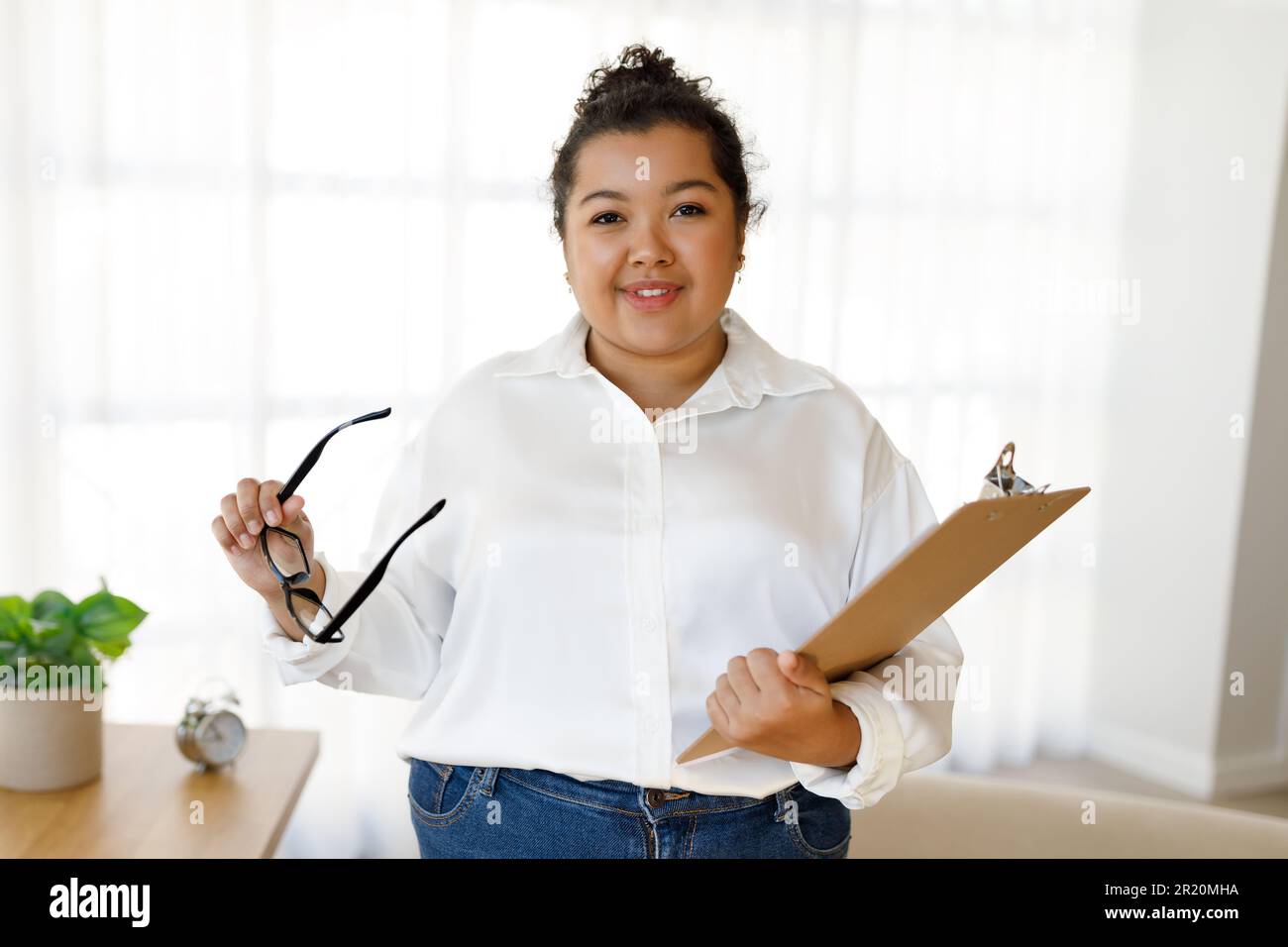 Portrait of professional family counselor hispanic woman posing in clinic Stock Photo