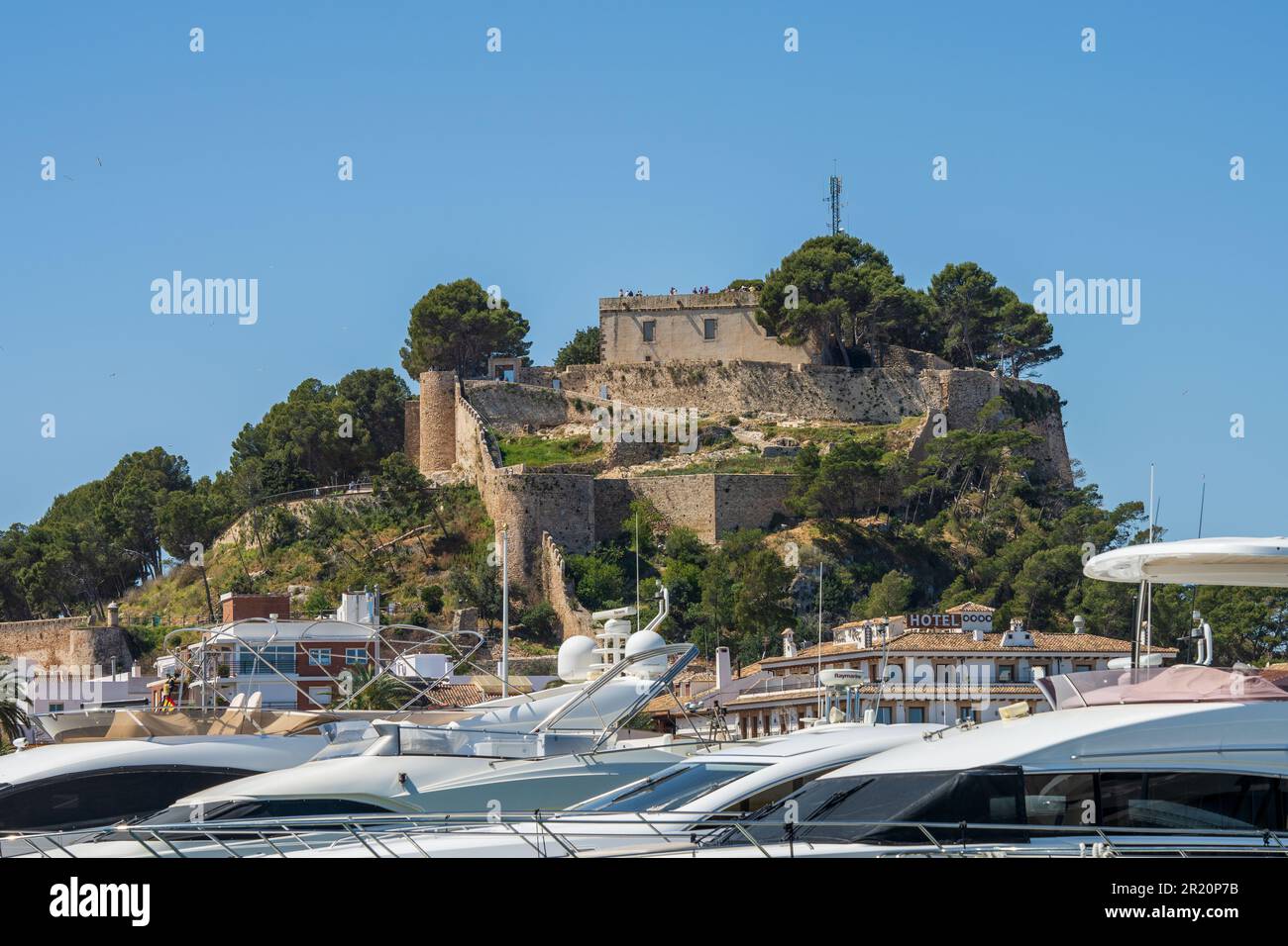 Harbor of Diana with Castell de Dénia with in the foreground luxury yachts and fishing boats Stock Photo