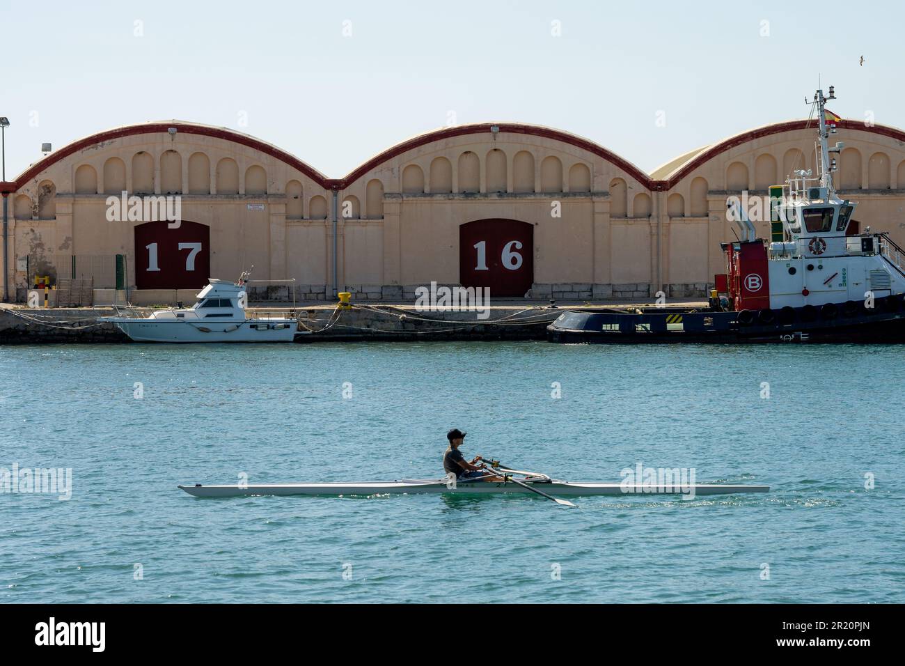 canoe in the harbor with buildings with the numbers 17 and 16 Stock Photo