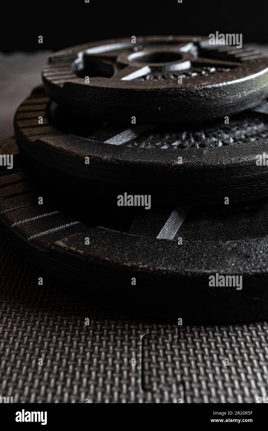 Stack of weight plates on dark background Stock Photo