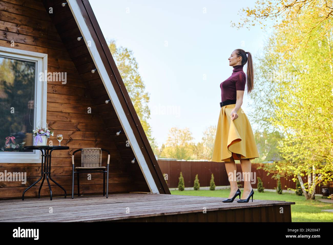 Woman walking on terrace of tiny house in the countryside during summer ...