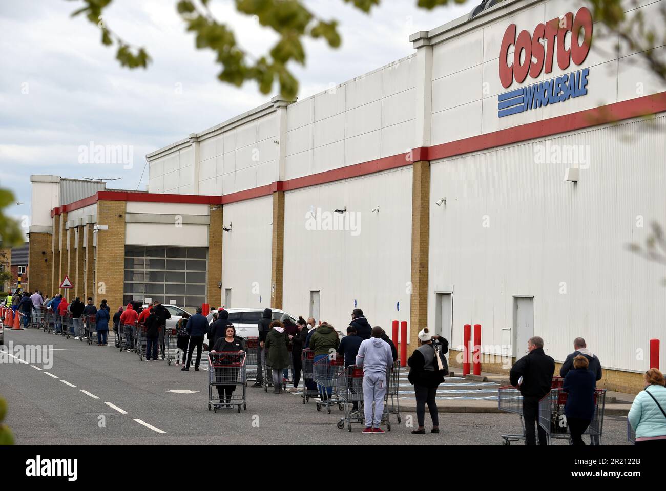 Photograph of people queuing outside of Costco in West Thurrock, Essex  during the COVID-19 pandemic Stock Photo - Alamy