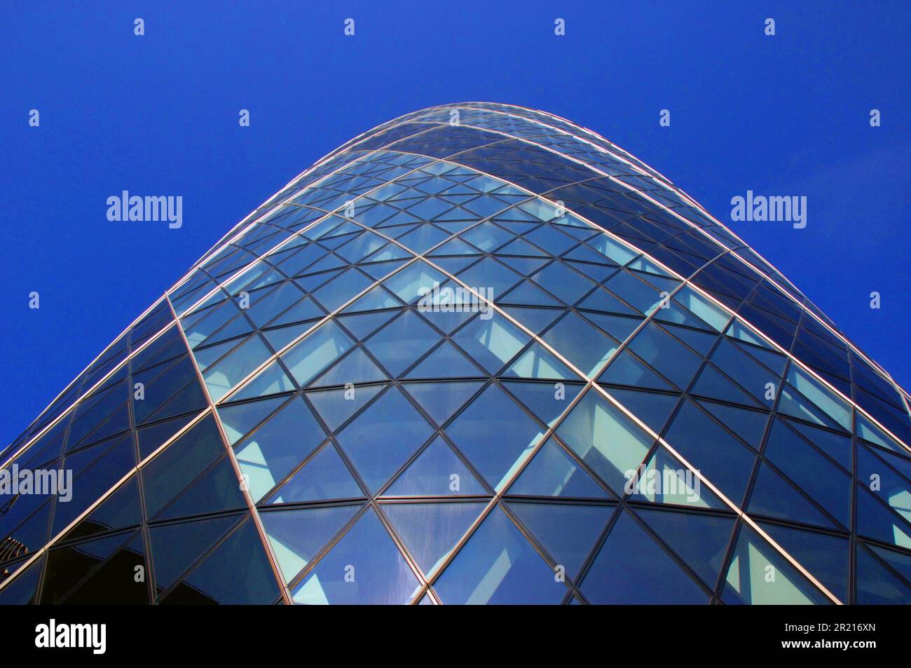 'The Gherkin' or Swiss Re Tower at 30 St Mary Axe in London's main financial district. It is 180 metres tall, making it the second-tallest building in the City of London, after Tower 42, and the sixth-tallest in London as a whole. The building was designed by Pritzker Prize-winner Lord Foster and ex-partner Ken Shuttleworth and Arup engineers, and was constructed by Skanska of Sweden between 2001 and 2004. Stock Photo