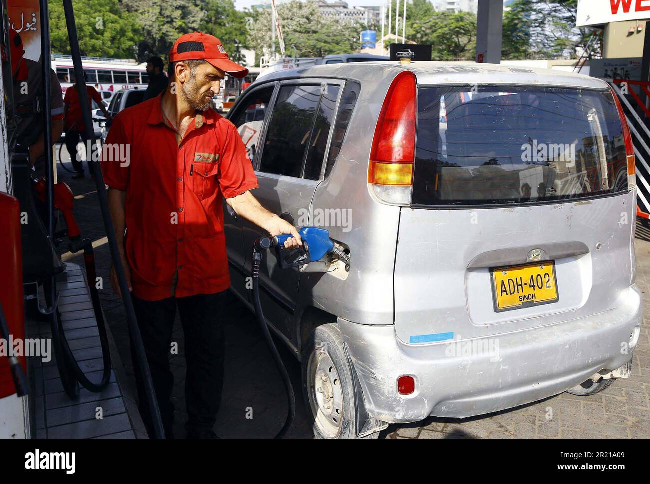 Karachi, Pakistan, May 16, 2023. Fuel station worker filling petrol in