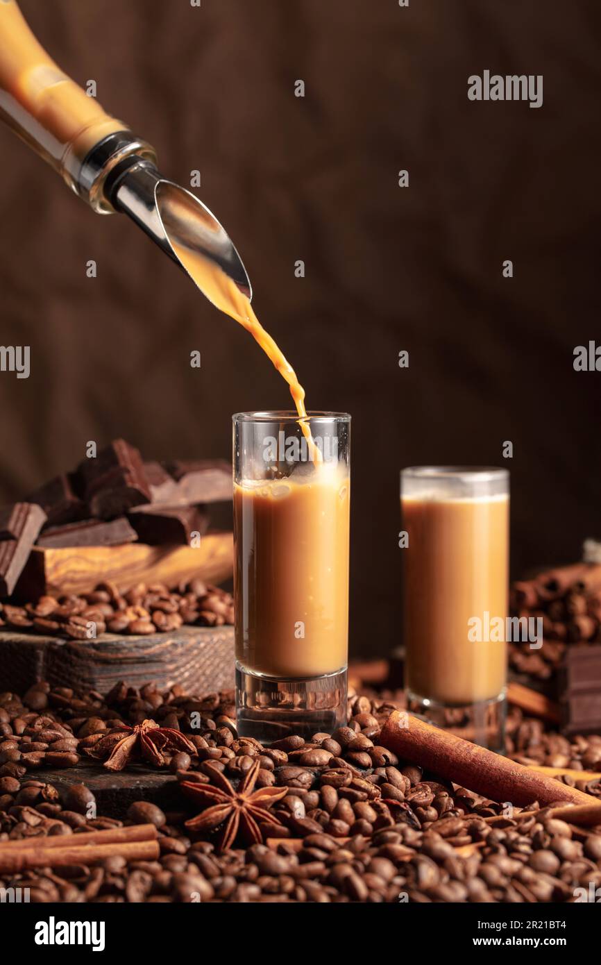 Irish cream and coffee liquor is poured from a bottle into a glass