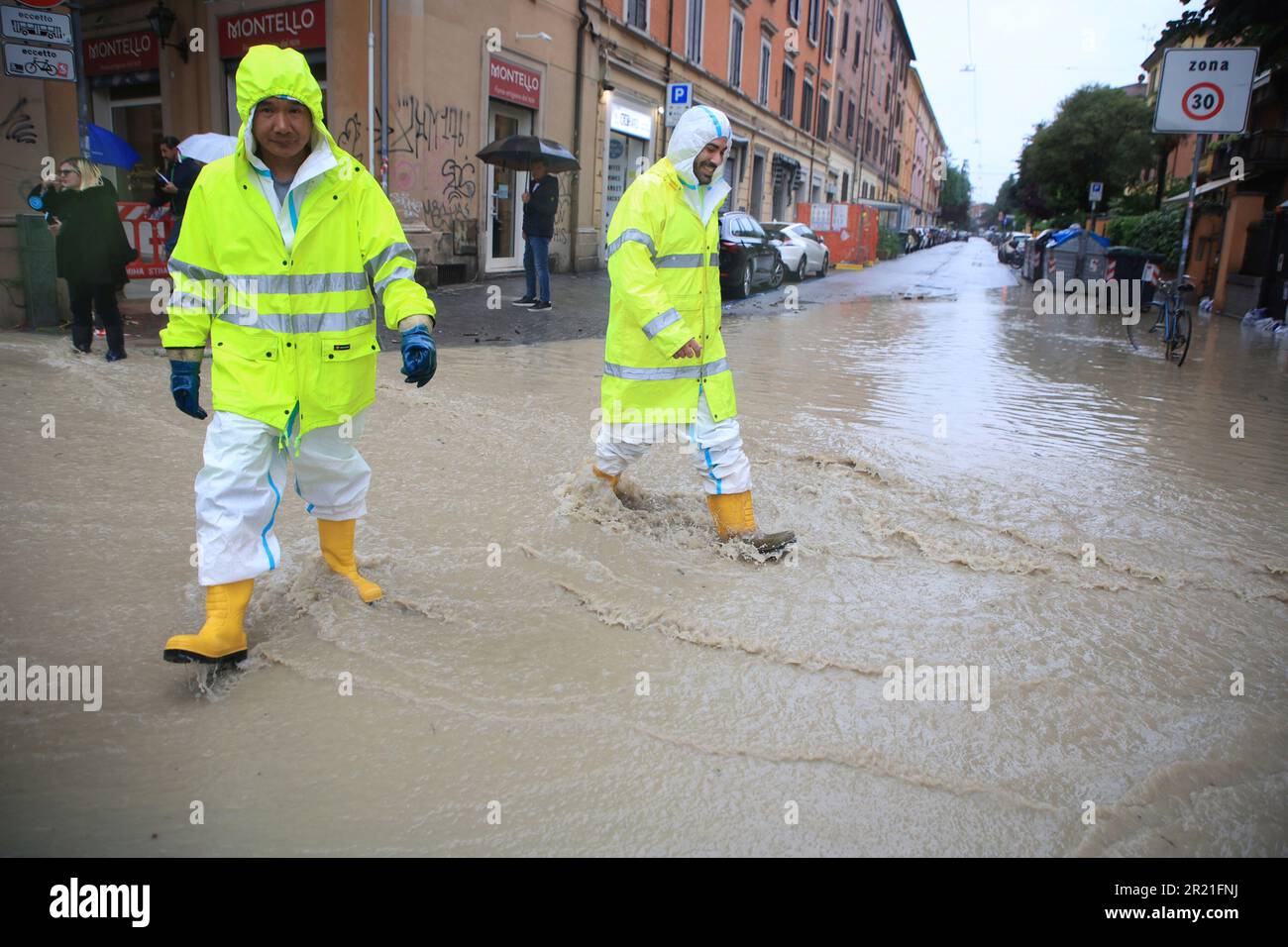 People crosses a flooded street in Bologna, Italy, Tuesday, May 16, 2023. Unusually heavy rains