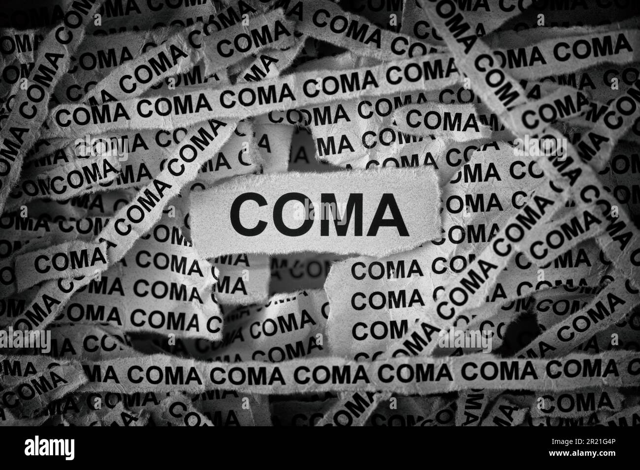 Strips of newspaper with the word Coma typed on them. Black and white. Close up. Stock Photo