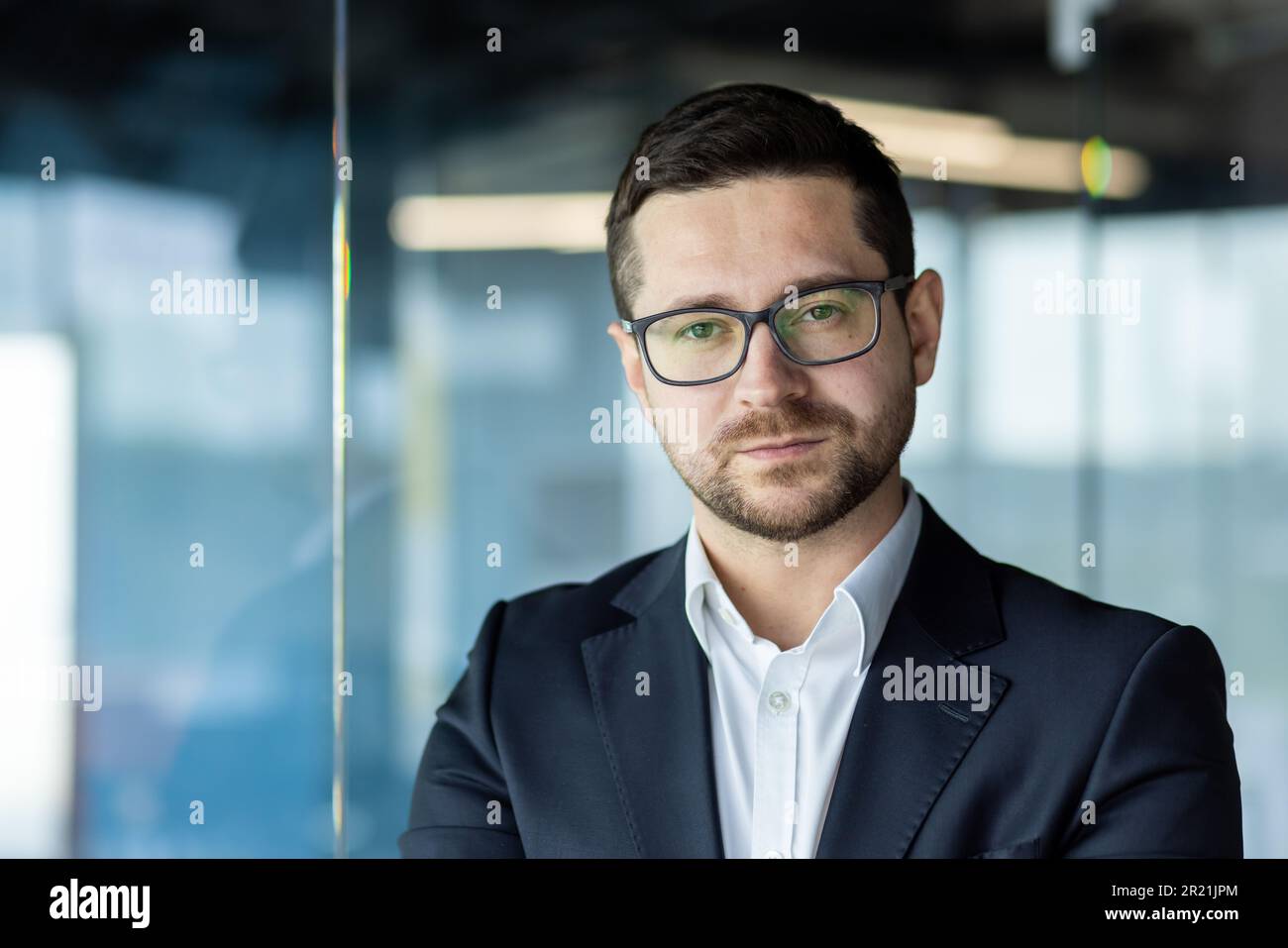 Close-up photo. Portrait of a successful young male teacher, business coach, personal growth trainer standing in the office and confidently and seriou Stock Photo