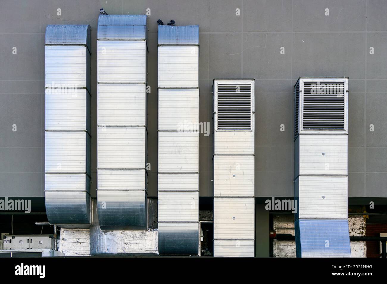 Galvanized tin square ventilation system pipeworks on a gray wall background Stock Photo