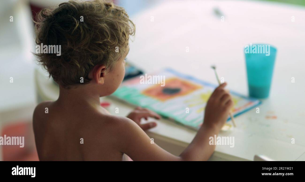 Child painting with aquarelle paint. Kid drawing and crafting at home Stock Photo