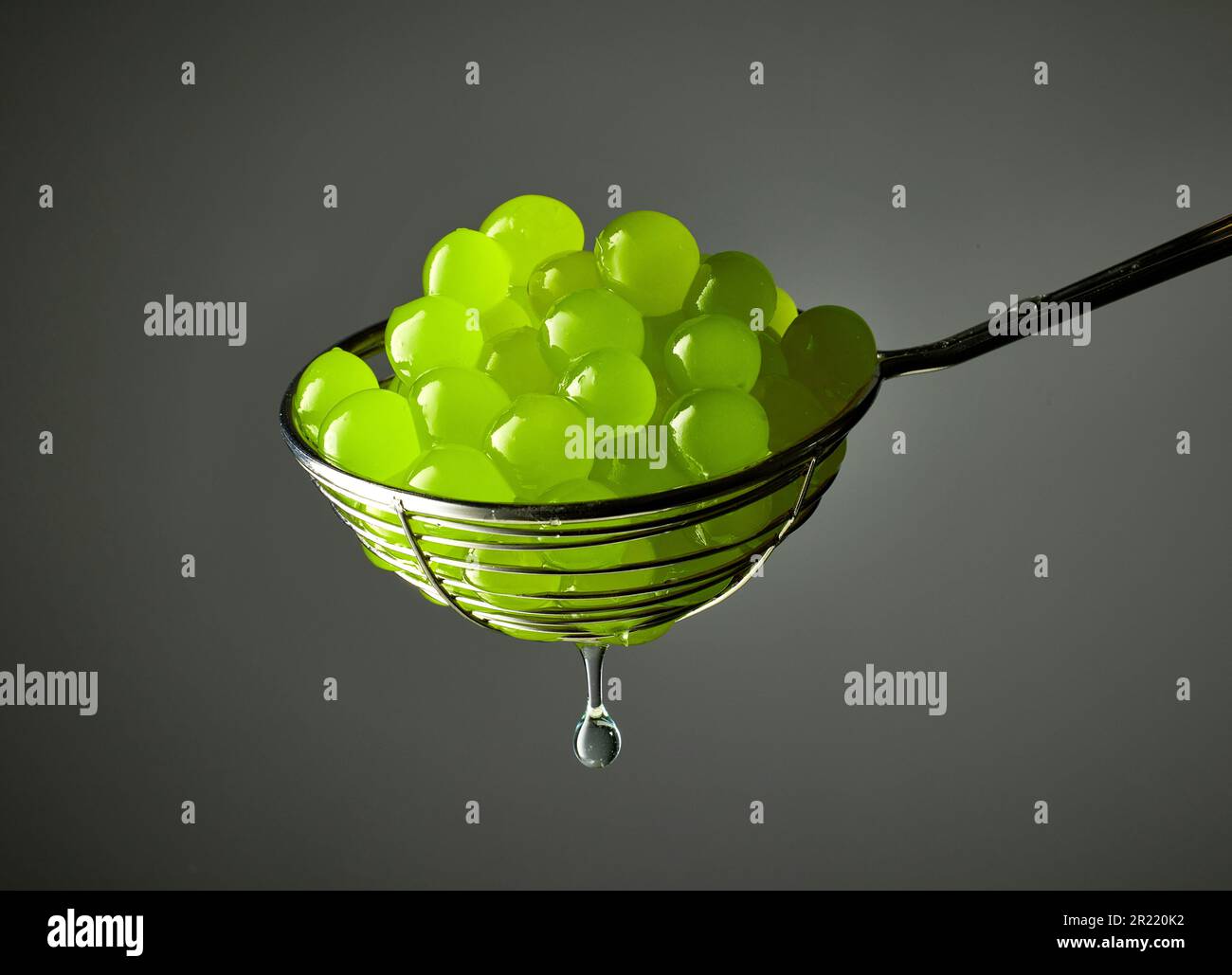 green jelly balls for making bubble tea in a strainer on grey