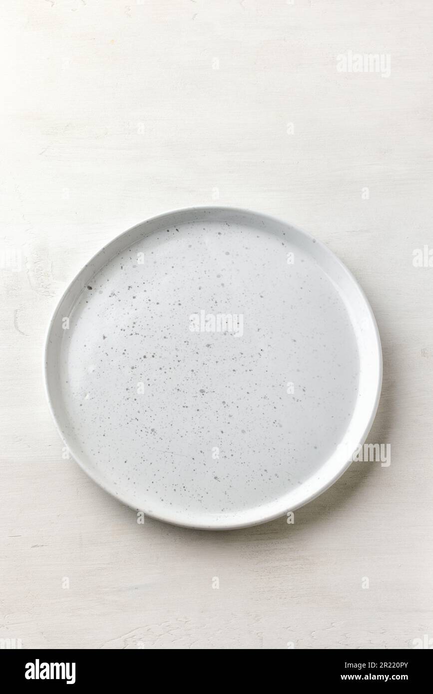 empty white plate on white table top view Stock Photo
