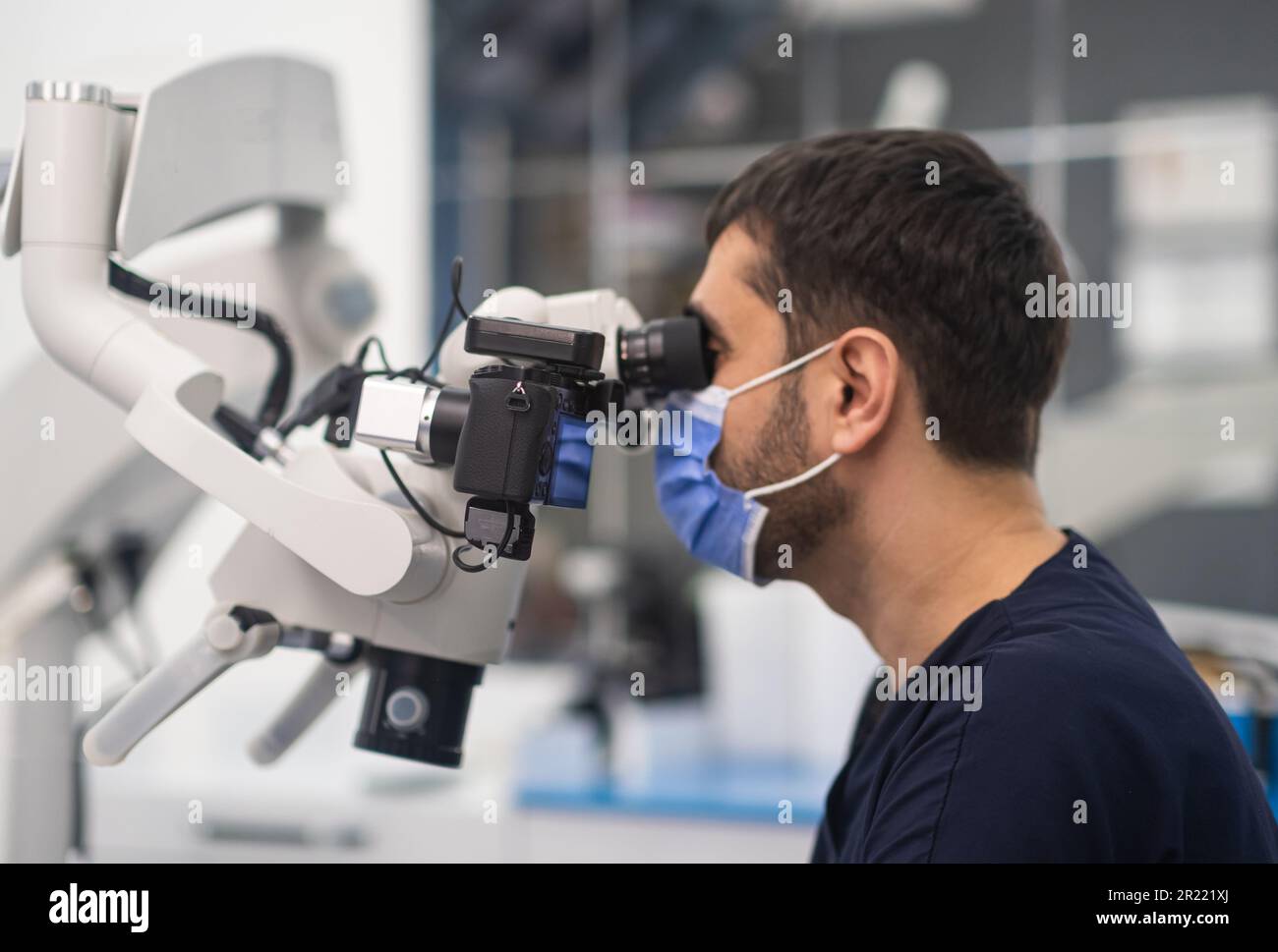 Concentrated dentist with medical mask on face looking in innovative ...