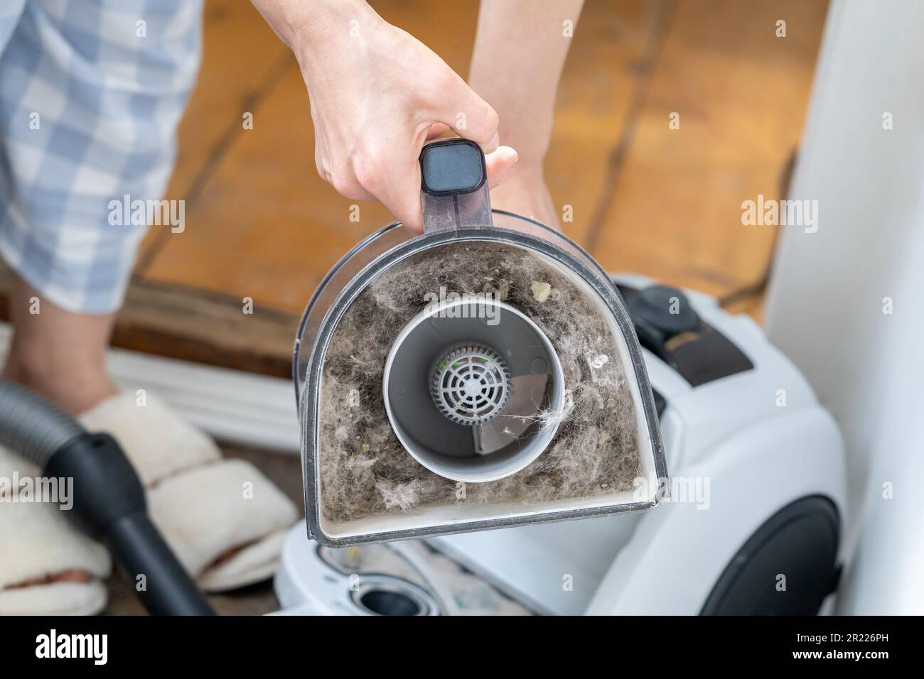 Female opening dust filter out of vacuum cleaner at home, hoover