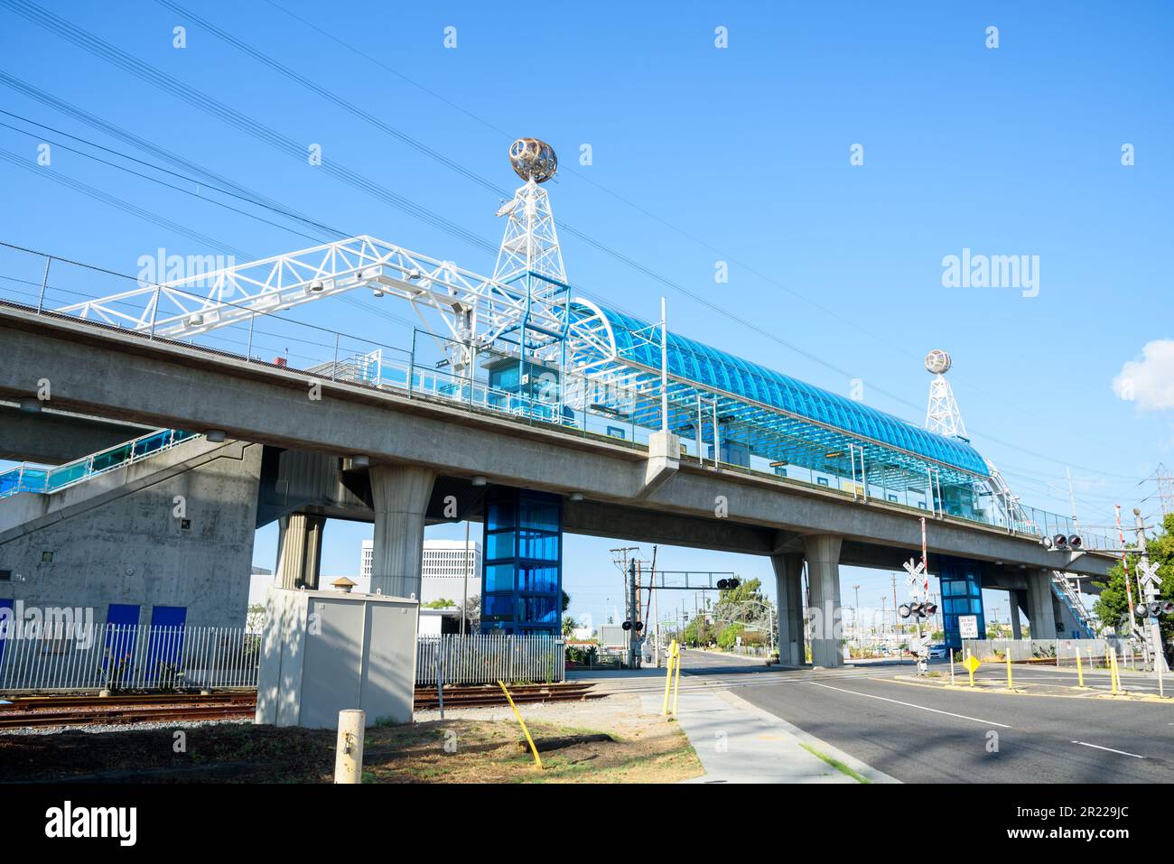 Modern elevated light rail station spanning a suburban road on a clear autumn day Stock Photo