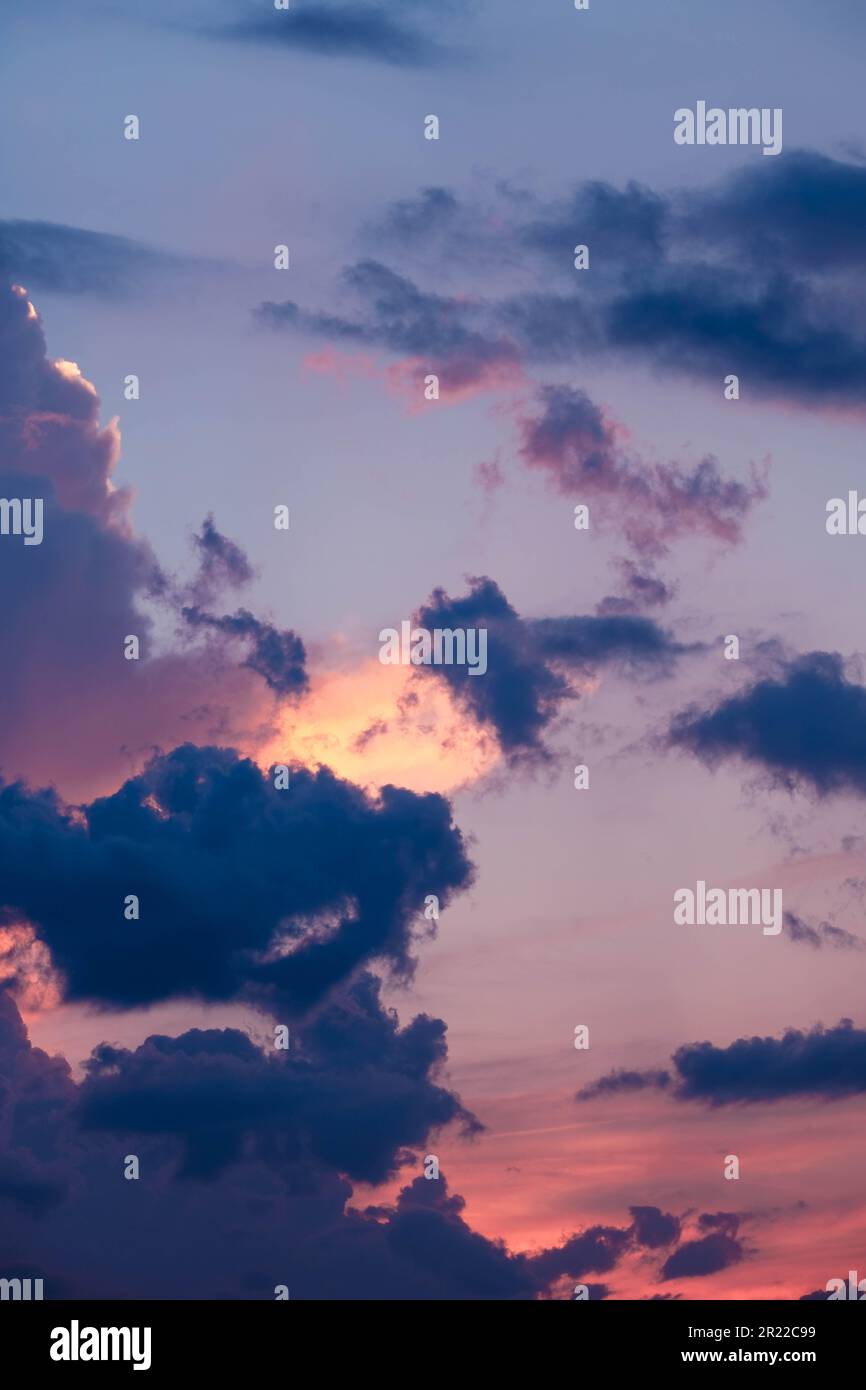 Intense pinks and blues in evening sky with glowing cloudscape Stock Photo
