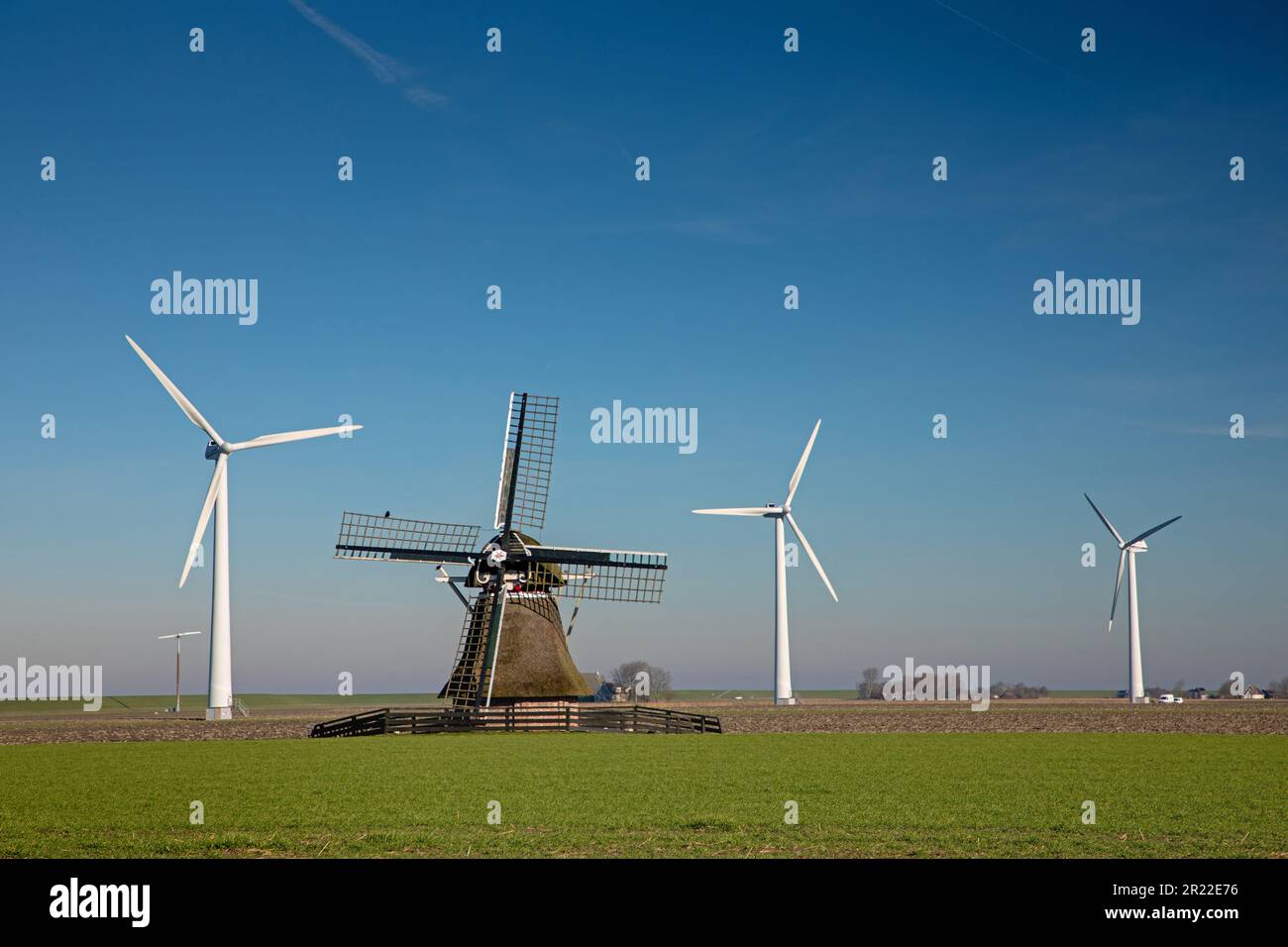 wind mill between wind wheels on a dyke, Netherlands, Frisia, Ferwert Stock Photo