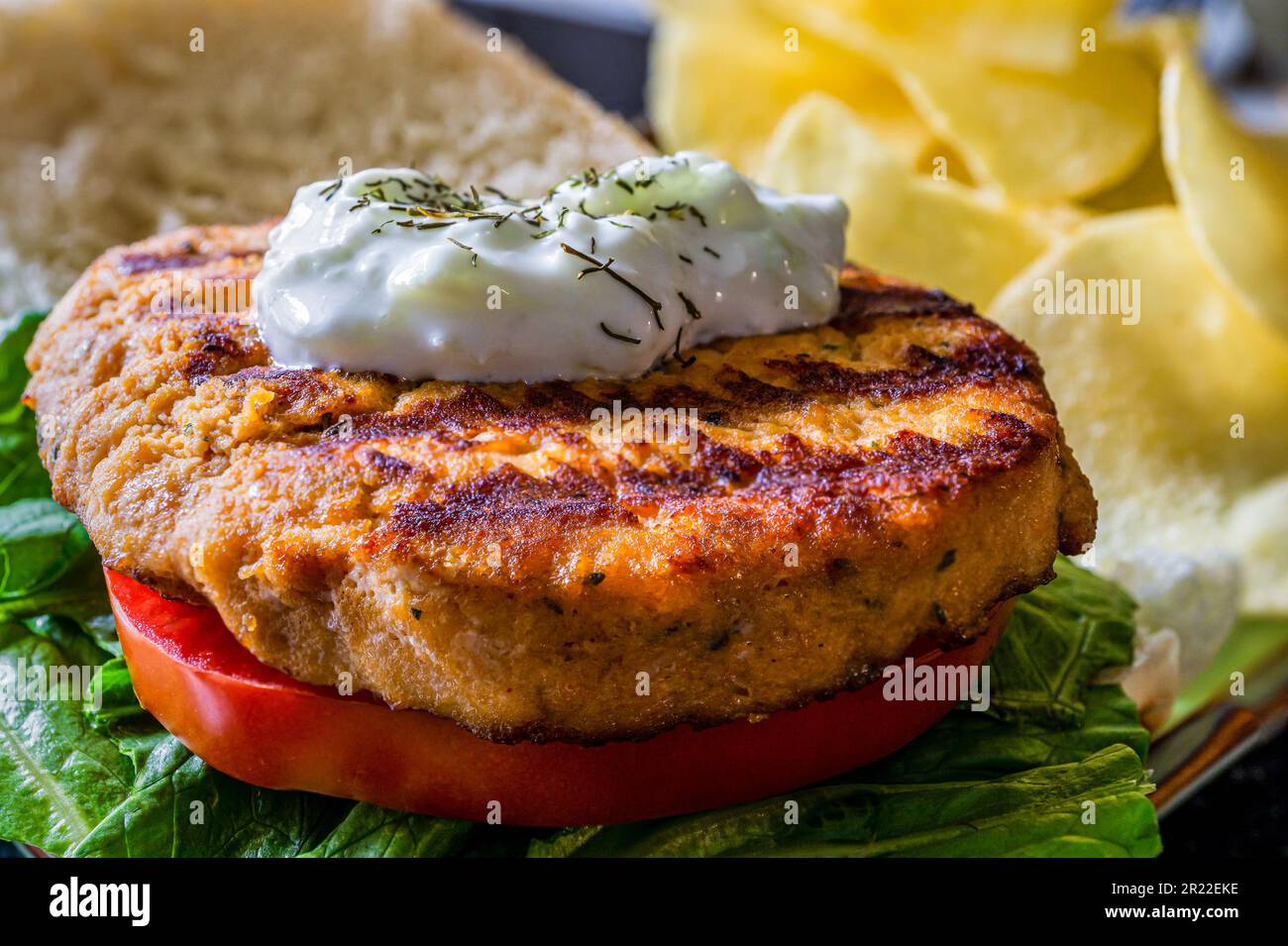Grilled salmon burger on a bun. Above shot. Stock Photo